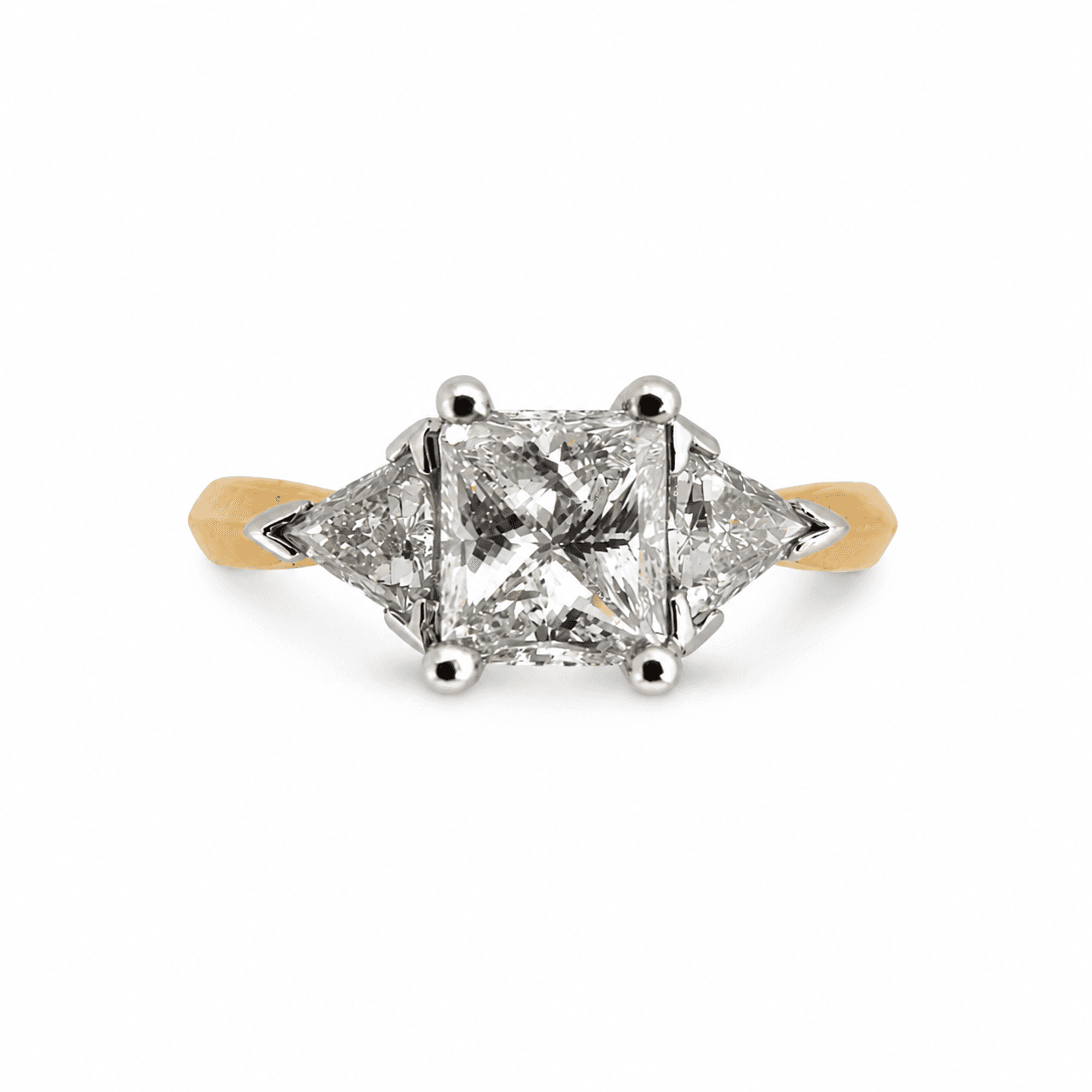 18K gold three-stone diamond ring viewed from top showing princess-cut center and trillion side stones