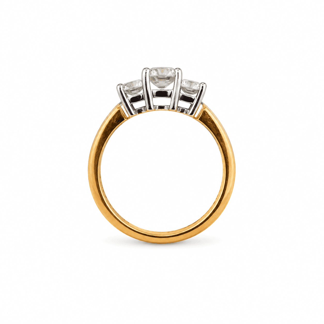 Three-stone diamond ring shown in profile view highlighting the platinum prong heads and 18K gold shank